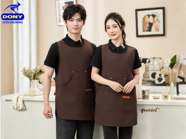 Sơ mi màu đen chủ đạo mang lại cảm giác sạch sẽ, tạp dề nâu ấm áp, gần gũi